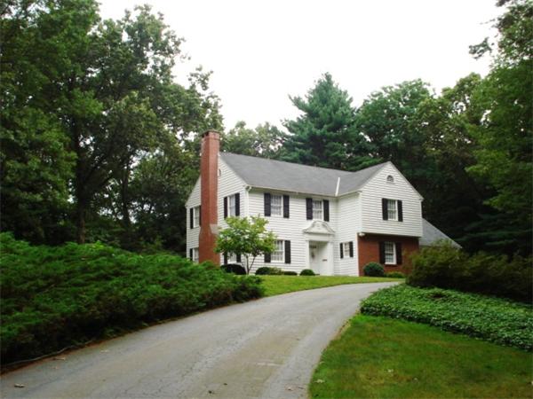 a view of a house with a big yard plants and large trees