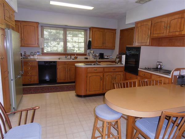 40 Woodsley Road Longmeadow, MA 01106 - Photo 12 of 16 a kitchen with stainless steel appliances granite countertop a stove a sink a microwave a dining table and chairs
