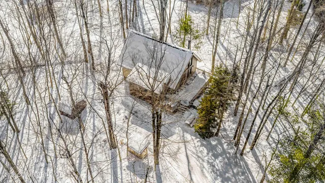 a view of a house with a yard covered in snow