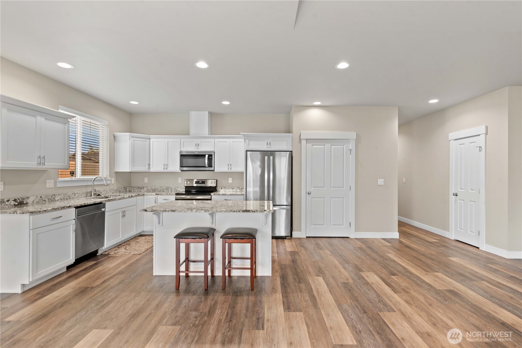 204 Pershing Circle Wenatchee, WA 98801 - Photo 11 of 33 a kitchen with white cabinets stainless steel appliances and wooden floor