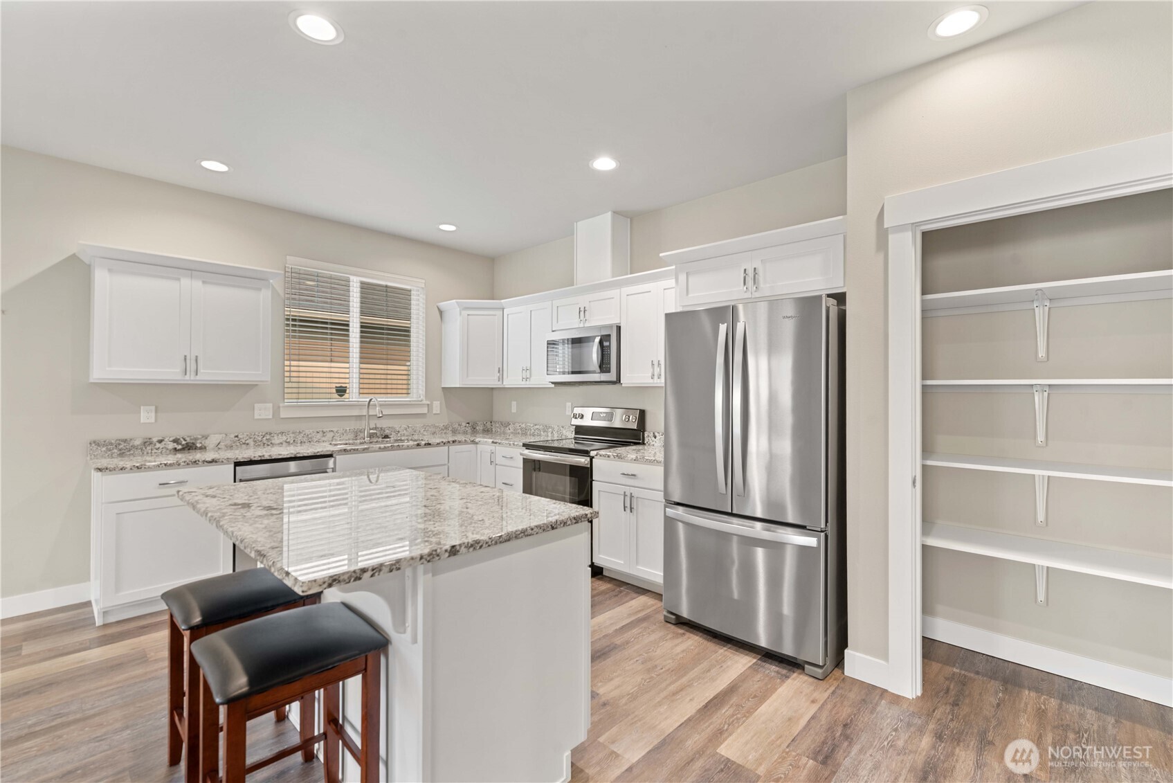 204 Pershing Circle Wenatchee, WA 98801 - Photo 10 of 33 a kitchen with kitchen island a stove a refrigerator and wooden floor
