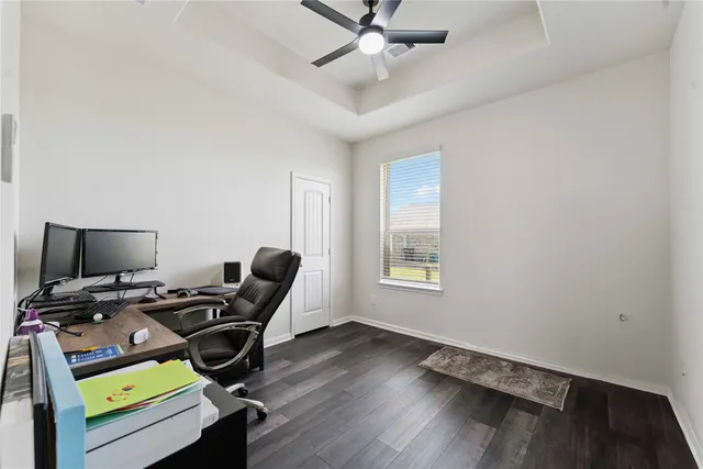 a view of workspace with wooden floor windows gym equipment and view of ceiling fan