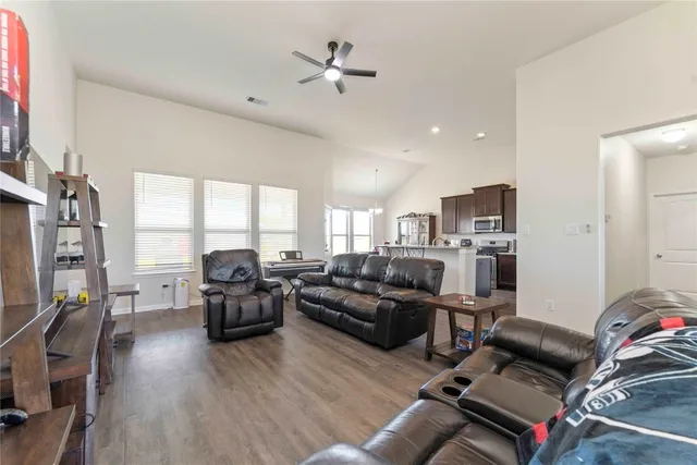 a living room with furniture kitchen view and a large window