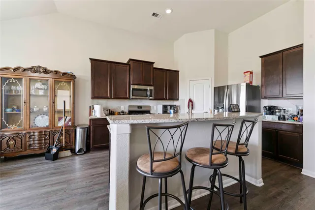 a kitchen with a table chairs refrigerator and cabinets