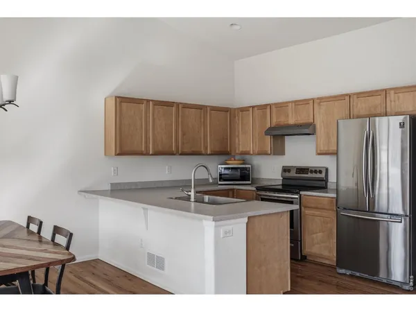 a kitchen with kitchen island a sink cabinets and stainless steel appliances