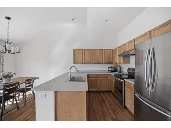 a kitchen with refrigerator cabinets and wooden floor
