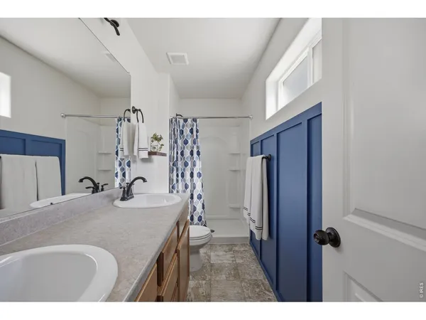 a bathroom with a sink vanity granite tub shower and a mirror
