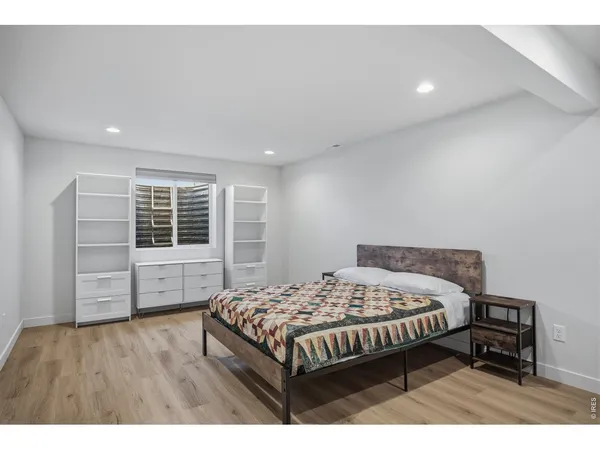 a bedroom with a bed window and a wooden floor