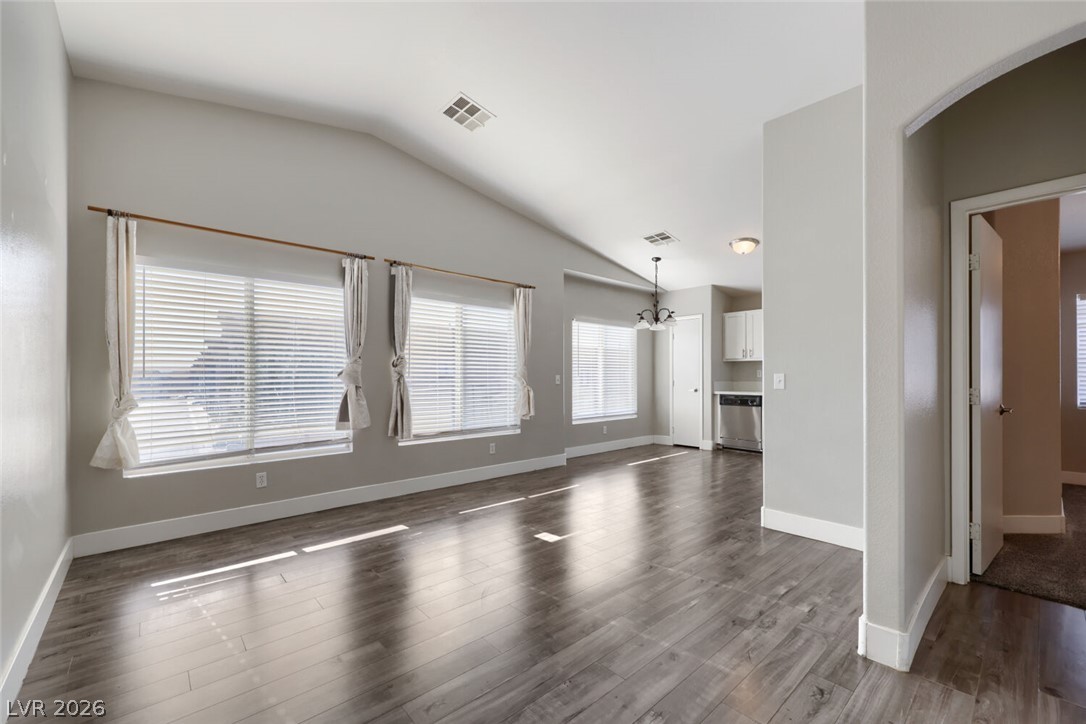 5985 High Steed Street, Unit 101 Henderson, NV 89011 - Photo 5 of 38 A spacious common area boasts lofty vaulted ceilings and lustrous hardwood flooring, flowing seamlessly into the kitchen.