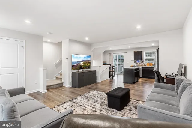 a living room with furniture kitchen view and a window