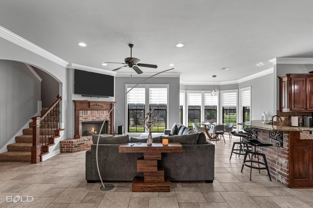 2220 Forest Hills Boulevard Haughton, LA 71037 - Photo 21 of 40 Spacious living area featuring tile flooring, a brick fireplace with a wood mantel, crown molding, and recessed lighting