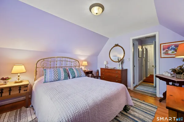 a bedroom with bed and wooden floor