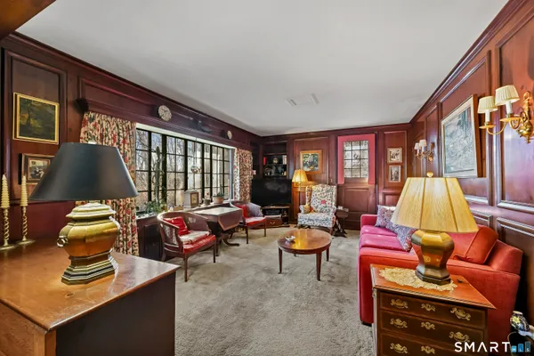 a living room with furniture a flat screen tv and a window
