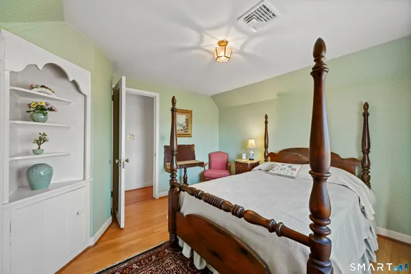 a bedroom with a bed dresser and a window