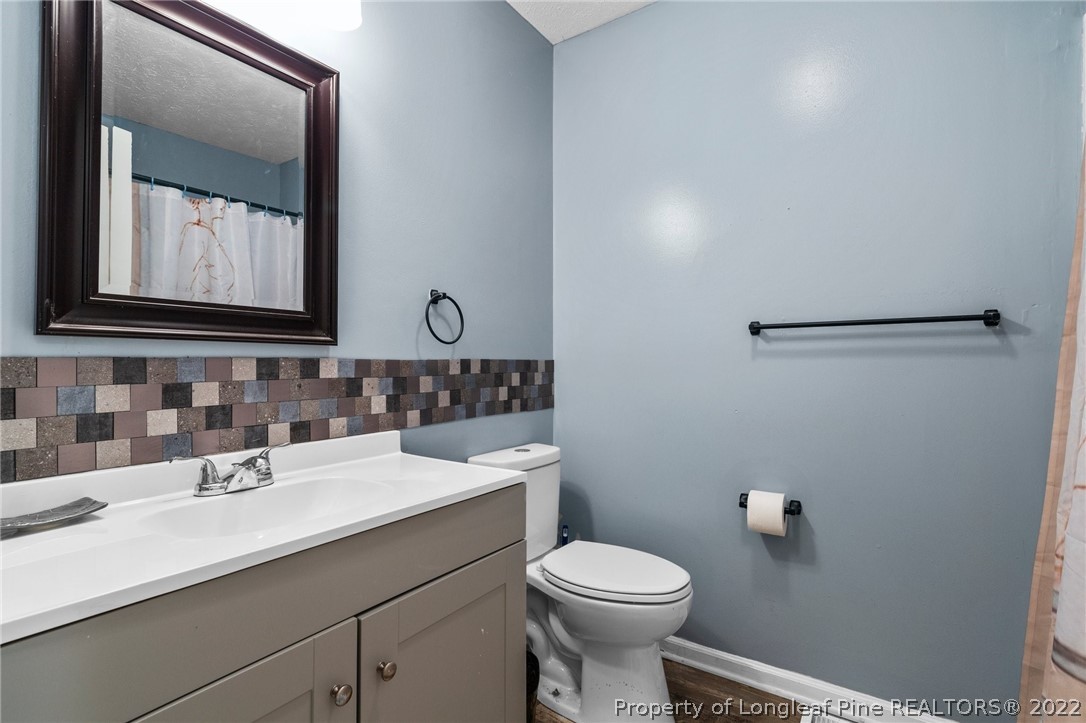 15921 Palmer Road Marston, NC 28363 - Photo 23 of 39 a bathroom with a toilet a sink a vanity and mirror