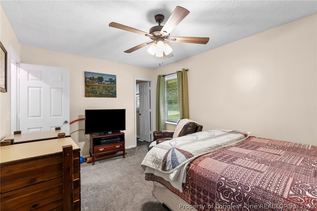 15921 Palmer Road Marston, NC 28363 - Photo 28 of 39 a bedroom with a bed window and a flat screen tv