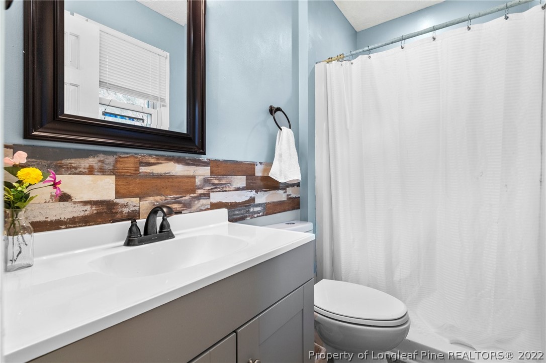 15921 Palmer Road Marston, NC 28363 - Photo 29 of 39 a bathroom with a sink a toilet and a mirror
