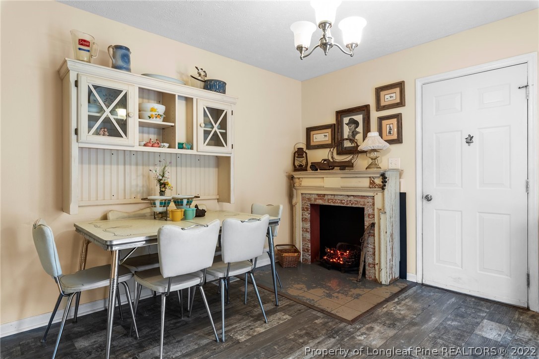 15921 Palmer Road Marston, NC 28363 - Photo 32 of 39 a dining room with furniture a fireplace and wooden floor