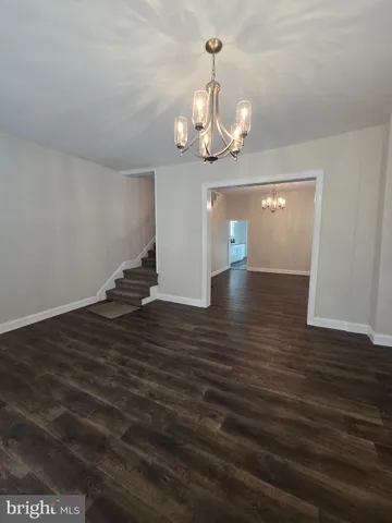 a view of a room with wooden floor and ceiling fan