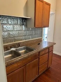 a sink with granite countertop a stove and a sink