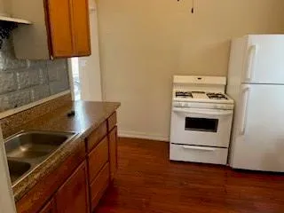 a kitchen with a stove cabinets and wooden floor