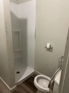 a bathroom with a granite countertop toilet and a shower