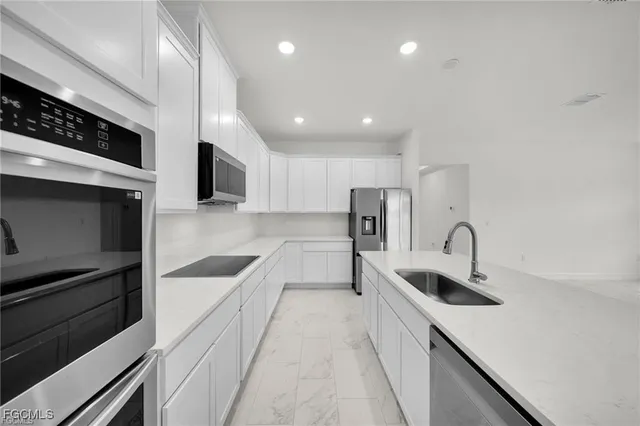 a kitchen with stainless steel appliances a sink a stove and a refrigerator
