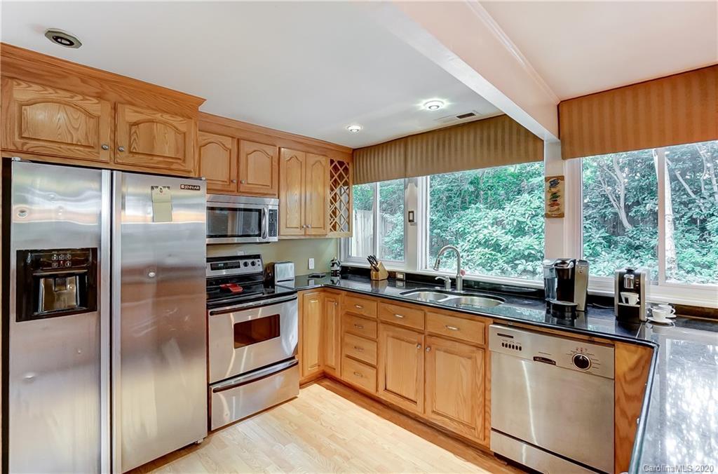 5314 Valley Forge Road Charlotte, NC 28210 - Photo 22 of 48 a kitchen with stainless steel appliances granite countertop a refrigerator a sink a stove a washer dryer and white cabinets