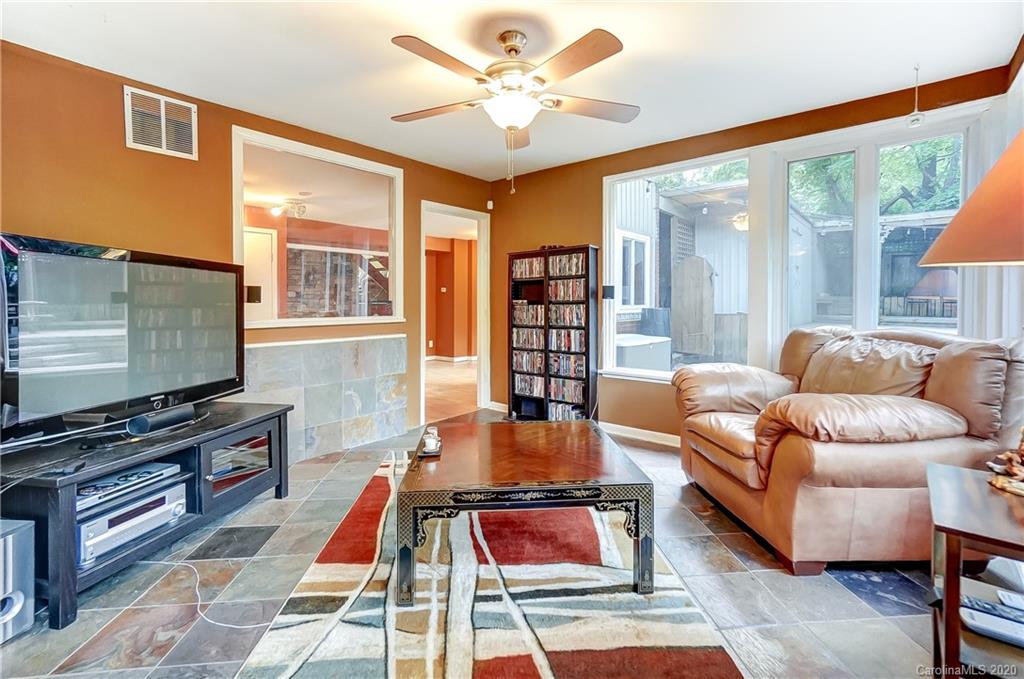 5314 Valley Forge Road Charlotte, NC 28210 - Photo 34 of 48 a living room with furniture a flat screen tv and a floor to ceiling window