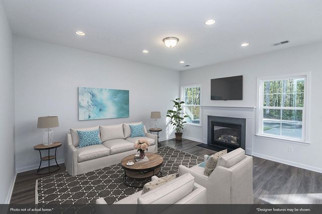 a living room with furniture fireplace and a large window