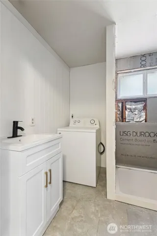 a utility room with cabinets washer and dryer