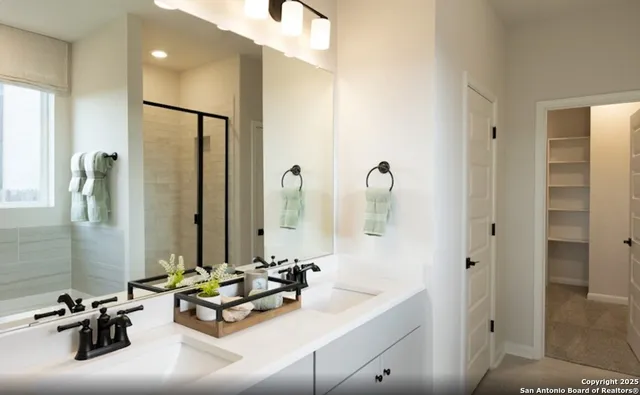a bathroom with double vanity sinks a mirror and a shower