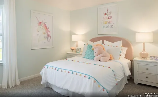 a bedroom with a bed and a lamp on dresser