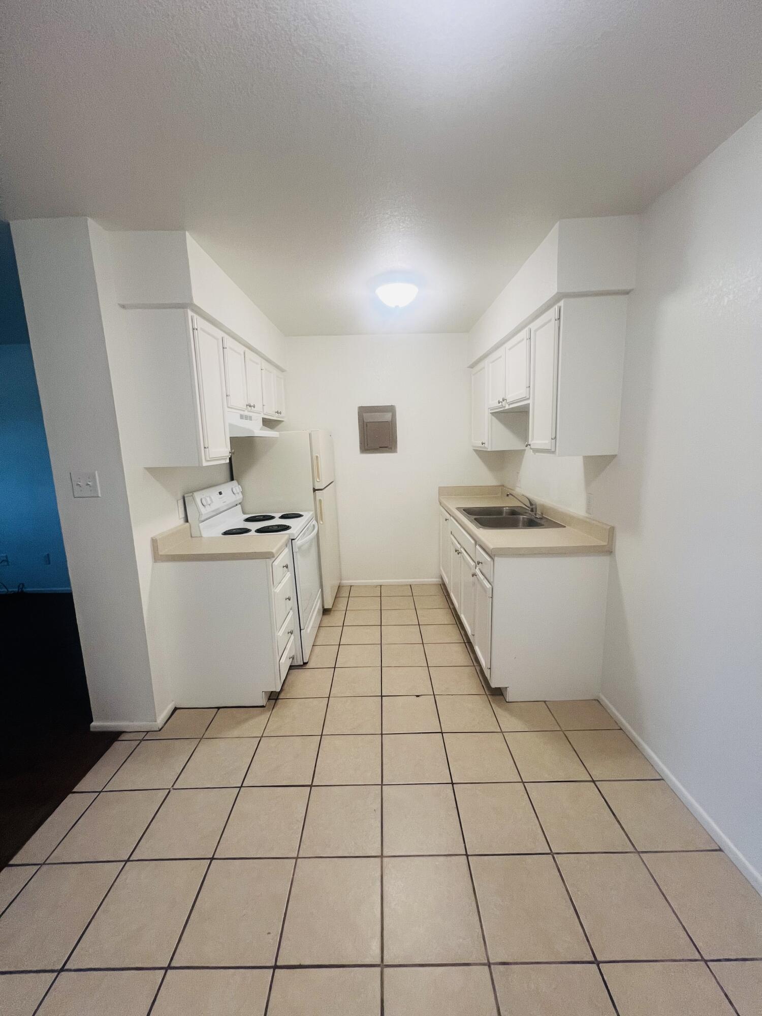 802 Matthew Avenue Sundown, TX 79372 - Photo 14 of 22 a kitchen with a sink a stove and white cabinets