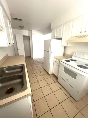 a kitchen with a stove cabinets and a window