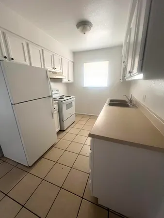 a kitchen with a sink a refrigerator and window