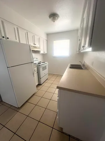 a kitchen with a sink a refrigerator and window