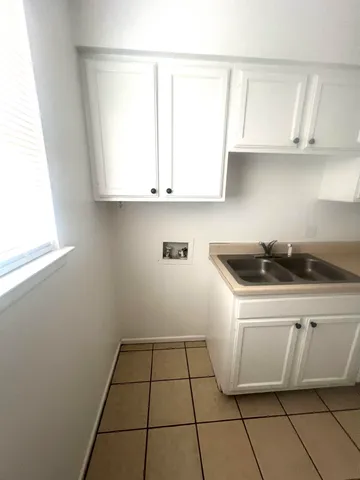 a kitchen with a sink cabinets and a window