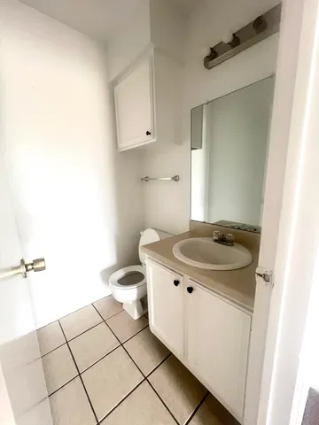 a bathroom with a granite countertop sink and a toilet