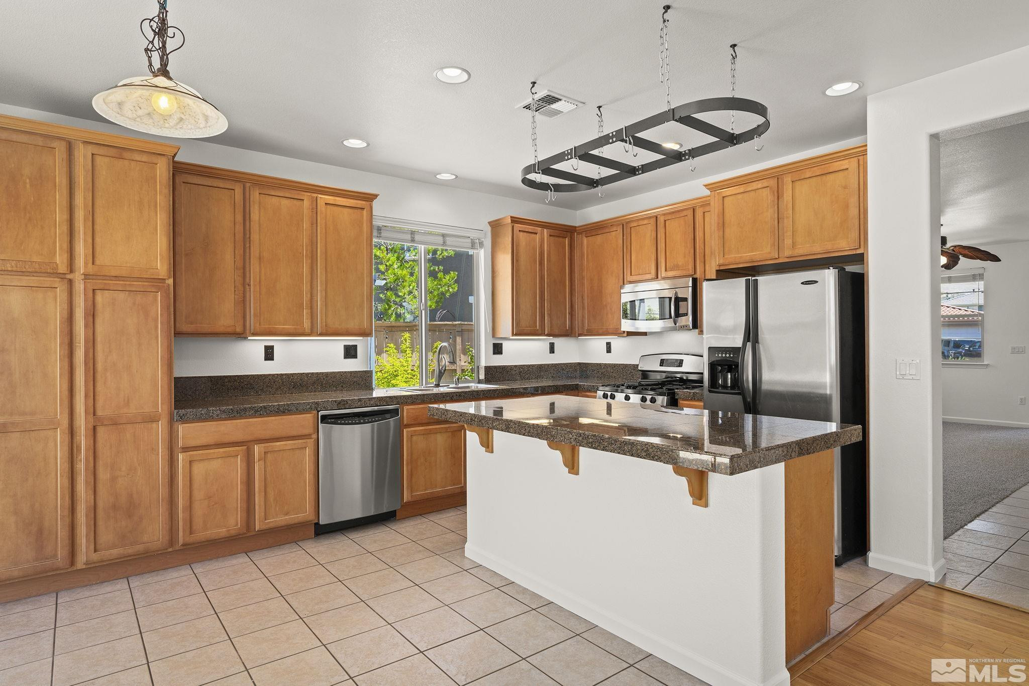 10655 Birch Point Court Reno, NV 89521 - Photo 2 of 19 a kitchen with stainless steel appliances granite countertop a sink a stove a refrigerator cabinets and chairs