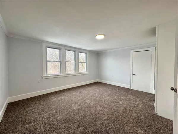 an empty room with windows and closet