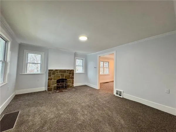 an empty room with a fireplace and windows