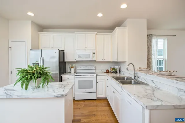 a kitchen with stainless steel appliances granite countertop a sink a stove and cabinets