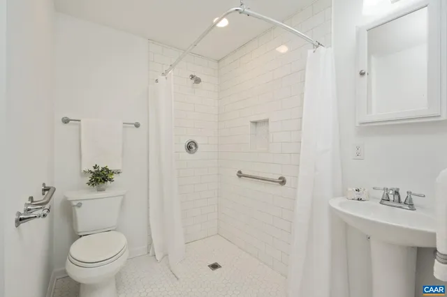 a bathroom with a shower toilet and sink