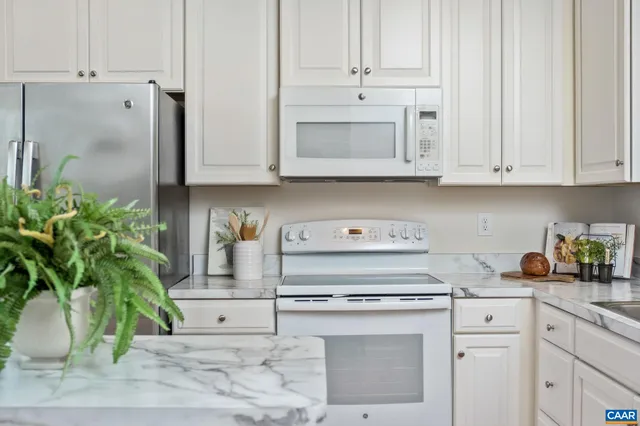 a kitchen with stainless steel appliances white cabinets and a stove top oven