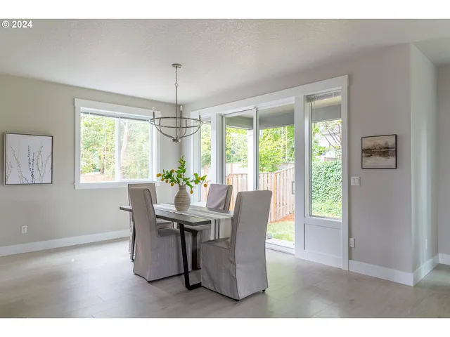 a dining room with furniture a chandelier and wooden floor