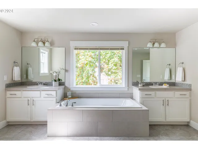 a spacious bathroom with a granite countertop tub sink and mirror