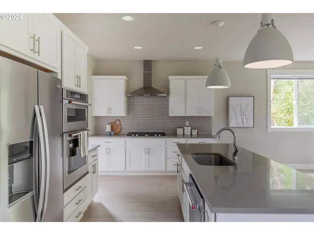 a kitchen with kitchen island a sink stainless steel appliances and window