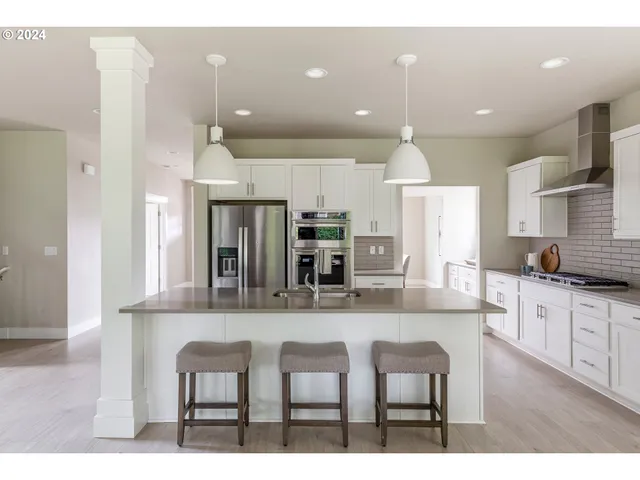 a kitchen with kitchen island granite countertop a table and chairs in it