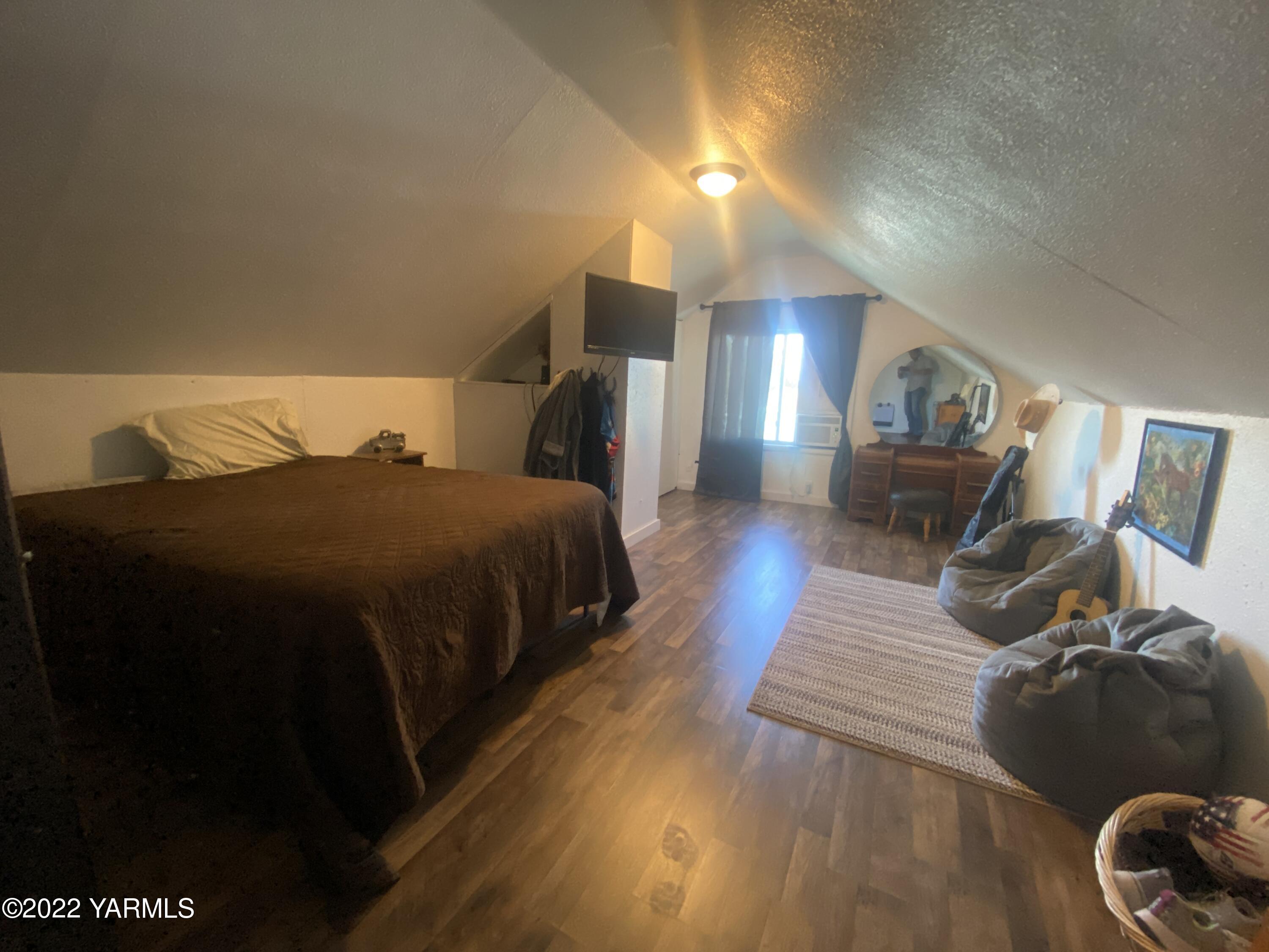 91 Arrowsmith Road Sunnyside, WA 98944 - Photo 13 of 19 a spacious bedroom with a bed and wooden floor